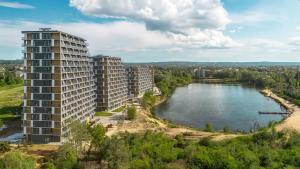 an apartment building next to a body of water at GOLD APARTMENTS Panorama Kwiatkowskiego in Rzeszów