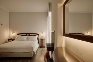 a bedroom with a bed and a large mirror at Hotel Le Mura in Lazise