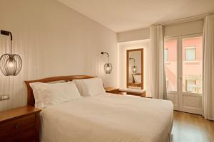 a bedroom with a white bed and a window at Hotel Le Mura in Lazise