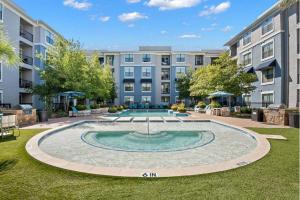a courtyard with a pool in front of a building at Charming 1BD Haven I Frisco I Pool, Gym, Work Space in Frisco