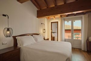 a bedroom with a large white bed and a window at Hotel Le Mura in Lazise