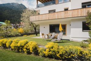 a house with a table and chairs in the yard at Gartenapart in Pfunds