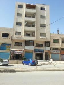 a blue car parked in front of a building at Z apartment in Az Zarqa