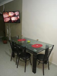 a dining room table with four chairs and a television at Z apartment in Az Zarqa +3 photos
