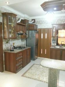 a kitchen with wooden cabinets and a stainless steel refrigerator at Z apartment in Az Zarqa