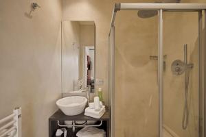 a bathroom with a glass shower and a sink at Hotel Le Mura in Lazise
