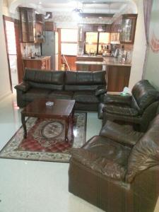a living room with a leather couch and a table at Z apartment in Az Zarqa