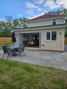 a patio with a table and chairs in front of a house at Inner cottage in Brent Knoll