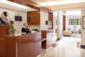 a man sitting at a reception desk in a lobby at Atlantic Hotel in Paris