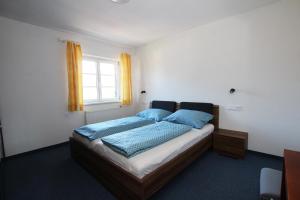 sypialnia z łóżkiem z niebieskimi poduszkami i oknem w obiekcie Ferienwohnung Wolfsberg w mieście Reutte +13 zdjęć