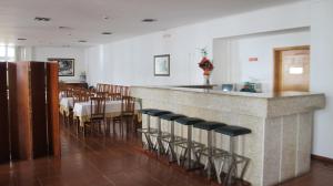 a restaurant with a bar with a table and chairs at Hotel Solar dos Pachecos in Lamego