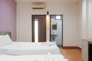 two white beds in a room with a bathroom at Collection O Khaosan Park in Bangkok +52 photos