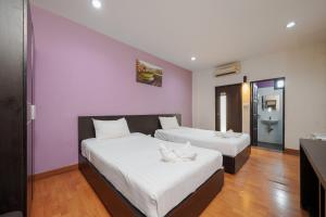 two beds in a room with pink walls at Collection O Khaosan Park in Bangkok
