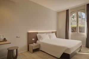 a bedroom with a white bed and a window at Hotel Le Mura in Lazise