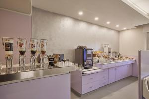 a restaurant with a counter with drinks and food at Hotel Le Mura in Lazise