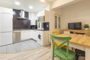 eine Küche mit einem Tisch und einem grünen Stuhl in der Unterkunft Súpercéntrico Santander in Santander