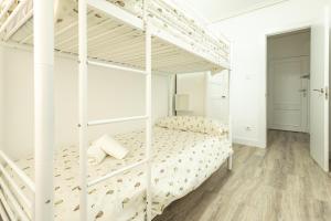 ein weißes Etagenbett in einem weißen Schlafzimmer in der Unterkunft Súpercéntrico Santander in Santander + 2 Fotos