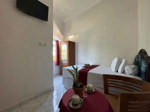 a bedroom with a bed and a table and a couch at Pepe Homestay in Singaraja