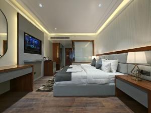 une chambre avec un grand lit et une télévision dans l'établissement The Mirage Simla, à Shimla 16 autres photos