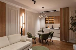 a living room with a couch and a table and chairs at Planet Residence NiNa in Niš