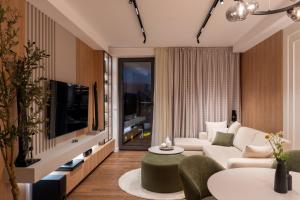 a living room with a couch and a tv at Planet Residence NiNa in Niš
