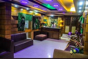 a bar with a couch and a counter in a room at Grand Plaza Hotel in Ābdullāpur