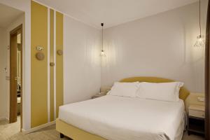 a bedroom with a large bed with white sheets at Hotel Le Mura in Lazise