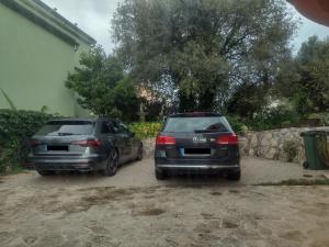 two cars parked next to each other in a driveway at Apartment Tomi in Brodarica
