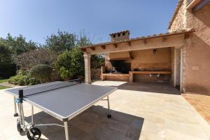 a ping pong table in front of a building at Villa para 10 personas con BBQ, piscina y terraza in S'Horta