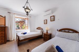 a bedroom with two beds and a window at Villa para 10 personas con BBQ, piscina y terraza in S'Horta +84 photos