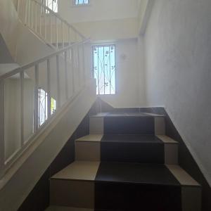 eine Treppe mit Treppenaufgang und Fenster in der Unterkunft Magnificent White House Semporna by The Minimalist in Semporna