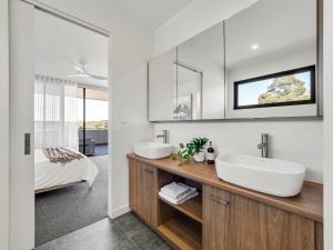 a bathroom with two sinks and a bed at Margaret's Luxe Penthouse - exclusive retreat! in Margaret River Town +20 photos