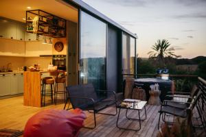 a balcony with chairs and a table and a kitchen at Suêrte cyprus in Akanthou