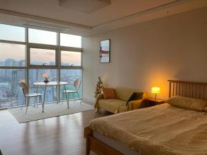 a bedroom with a bed and a couch and a table at 분위기 좋은 초고층 제니하우스 in Seoul +90 photos