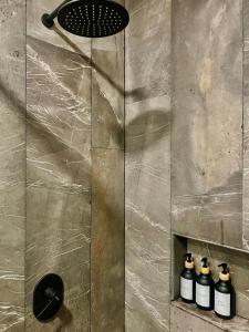 a shower with three bottles in a shower niche at Luxury 2bdr Apt with Direct Pool in Paramar Black in Tulum