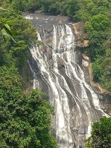 a waterfall on the side of a mountain at Kirindi Ella Eco Resort in Pelmadulla