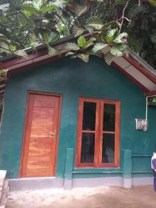 a blue house with a door and a window at Kirindi Ella Eco Resort in Pelmadulla