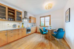 a kitchen with a table and some blue chairs at Haus mit Donaublick, Terrasse und Garten in Dürnstein