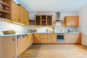 a large kitchen with wooden cabinets and appliances at Haus mit Donaublick, Terrasse und Garten in Dürnstein +5 photos