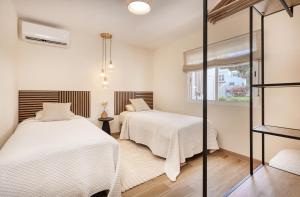 ein Schlafzimmer mit zwei Betten und einem Fenster in der Unterkunft Waves & Pines Apartment El Paraiso, Benamara in Estepona + 43 Fotos