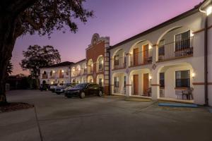 a row of buildings with cars parked in a parking lot at Travelodge by Wyndham Hotel & Cottages St Augustine - Historic in Saint Augustine