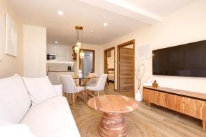 ein Wohnzimmer mit Sofa und Tisch in der Unterkunft Waves & Pines Apartment El Paraiso, Benamara in Estepona