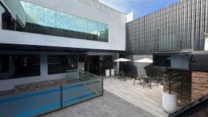 a building with a patio with tables and chairs at Hotel Capelli Talca in Talca