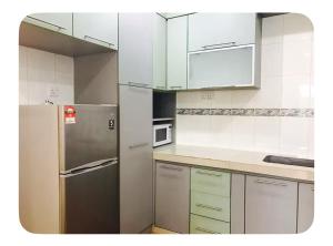 a kitchen with a stainless steel refrigerator and white cabinets at Semi D 4BR 1min to KSL & Holiday Plaza 8-10pax in Johor Bahru