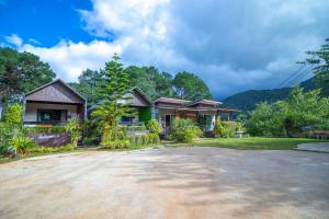 a house with a large driveway in front of it at ฟินอินดอย in Chom Thong