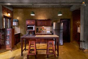 a kitchen with a large island with two bar stools at Gracevilla in Pīrmed