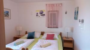 sypialnia z 2 łóżkami, 2 lampami i oknem w obiekcie D,apartman w mieście Omišalj