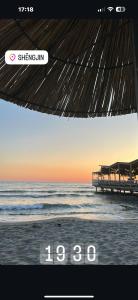 ein Bild von einem Strand mit einer Uhr darauf in der Unterkunft Your beach house holidays with all utilities in Shëngjin + 6 Fotos