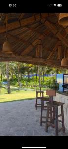 a table and chairs under a wooden roof at Oceanview apartment in The Arena Cam Ranh resort in Îlot Ba Ninh