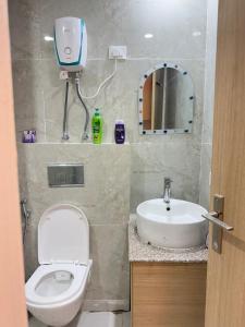 een badkamer met een toilet, een wastafel en een spiegel bij Skyline kaveri in Greater Noida